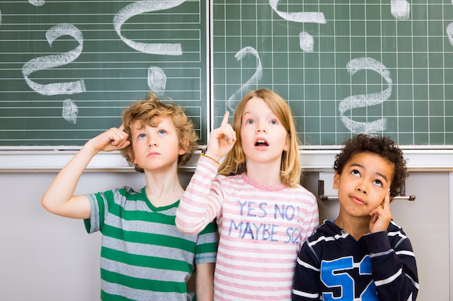 Kinder nachdenklich an der Tafel Schule